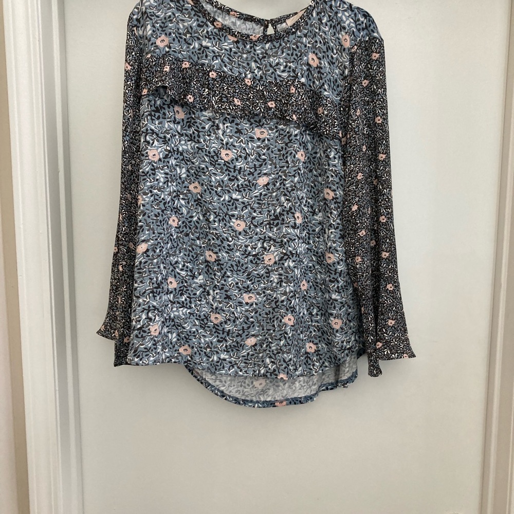 Floral shirt with ruffle across chest.